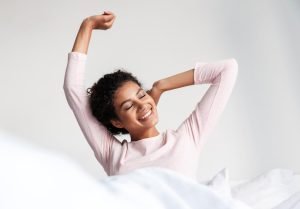 Woman waking refreshed after sleeping on a Restonic bed
