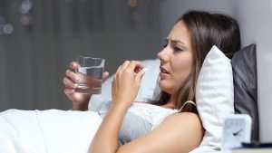 Woman sneezing in bed